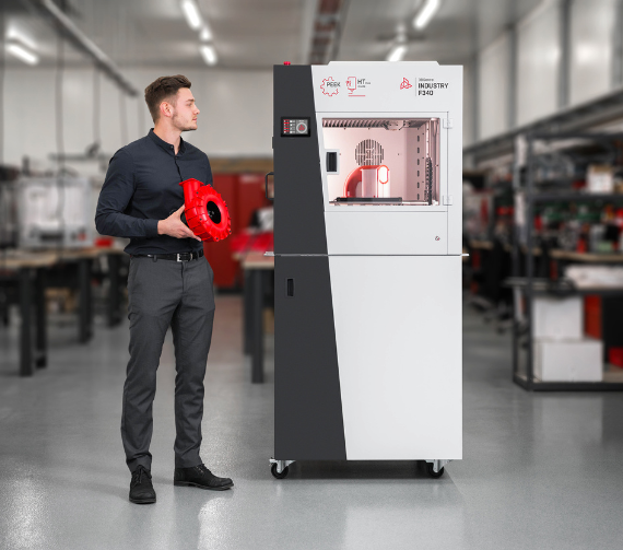 A man stood next to the large Industry F340 3D printer