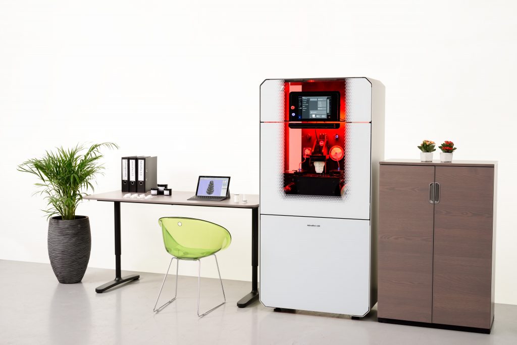an admatec 3d printer alongside a modern desk and filing cabinet