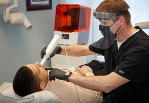 A dentist scanning the teeth of a patient