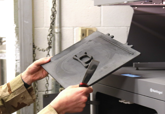 Soldier taking a printed part from a Markforged 3D printer