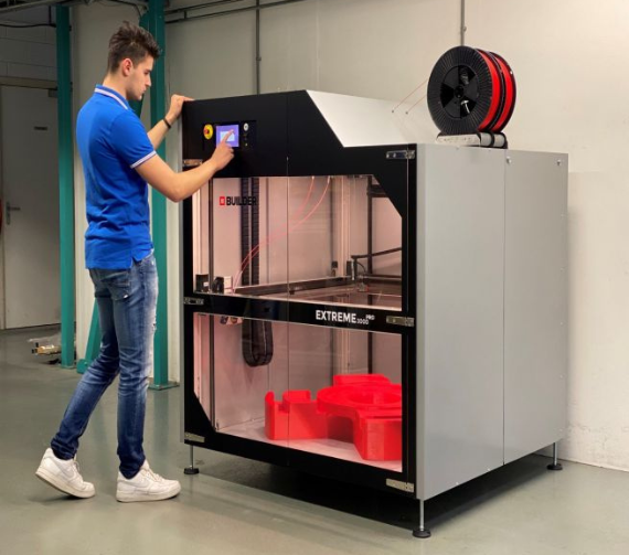 A man operating a Builder Extreme 3000 PRO, large scale industrial 3D printer.