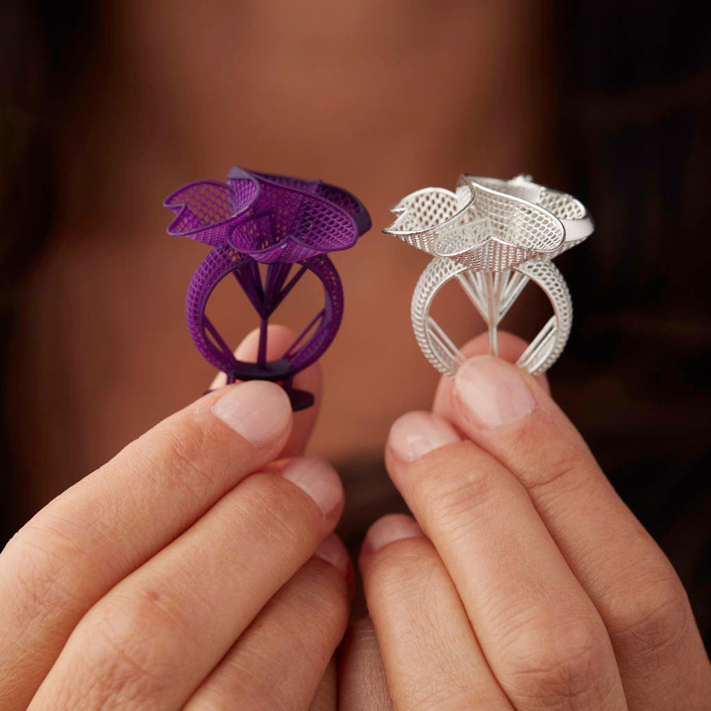 a woman holding two 3d printed rings (jewellery) in castable wax