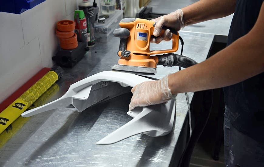 a man finishing a 3d print from the zortrax 300 3d printer