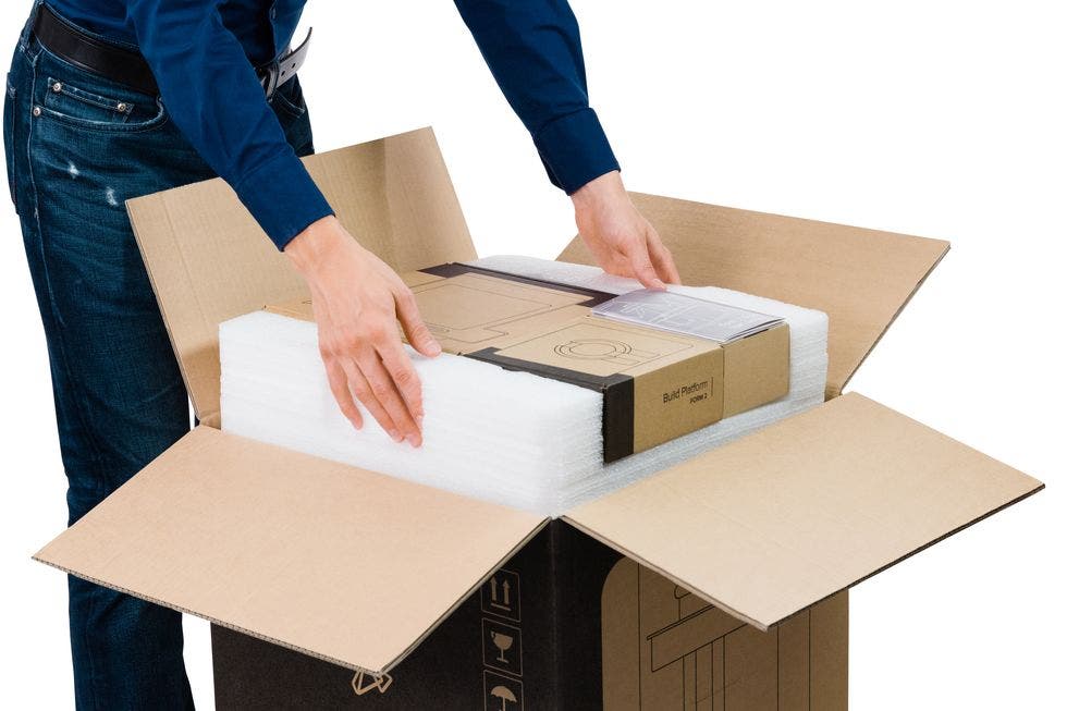 a man removing a formlabs 3d printer build platform from its delivery box