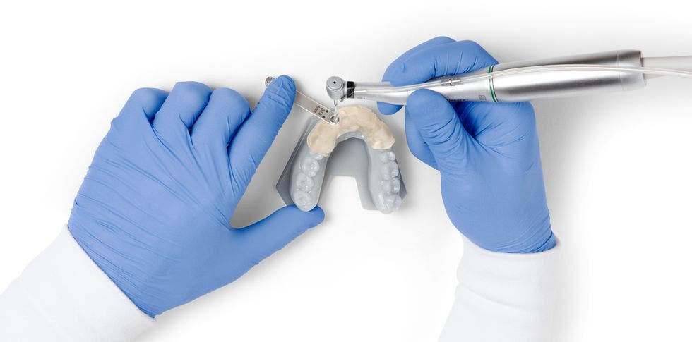 a dentist practising techniques on a 3d printed model of lower teeth in sg dental resin