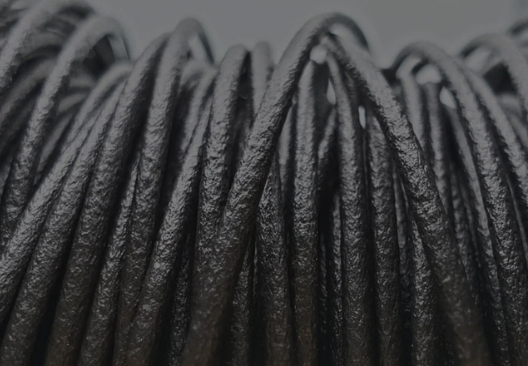 A close up photograph of a spool of black filament.