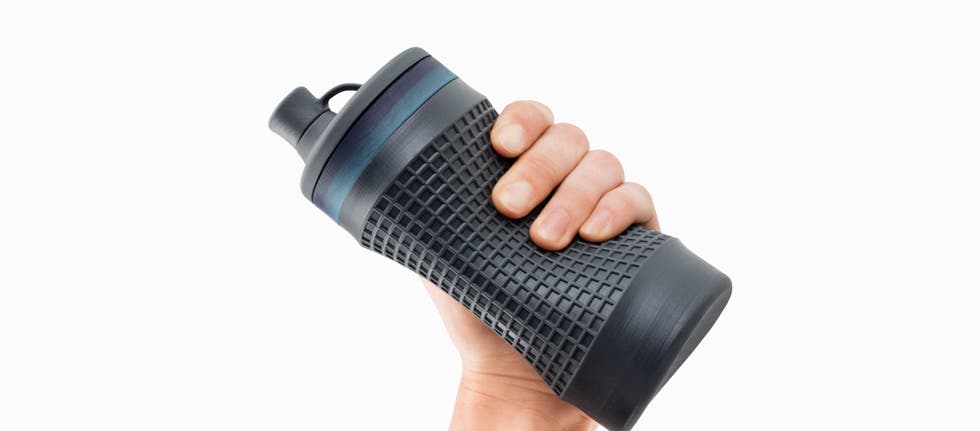 a bottle shaped 3d printed part in flexible resin being held in someone's hand