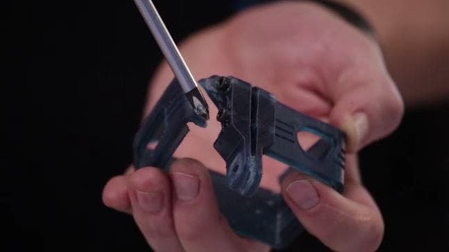 a gopro 3d printed skateboard mount being opened up with a screwdriver