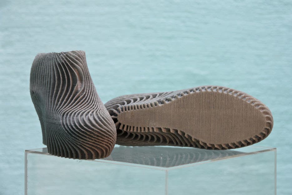 3d printed high heels stood on a glass column