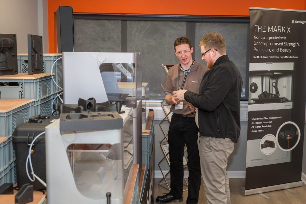 in the additive-x showroom, two men chat about the metal X markforged printer
