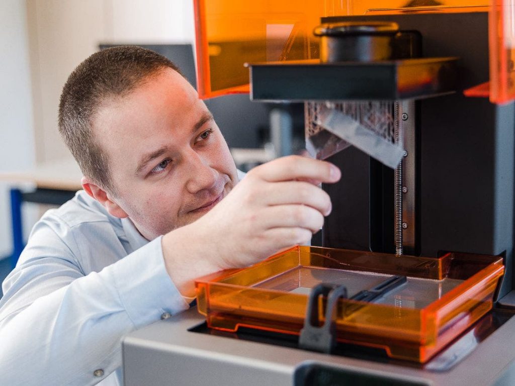a man removing a print from a formlabs 3d printer