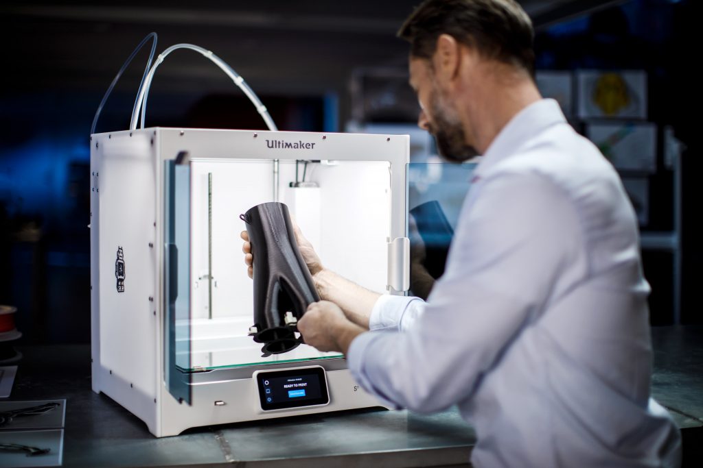 a man removing a print from an ultimaker s5 3d printer