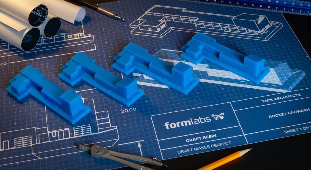 a work bench with formlabs draft resin parts on the top of the blueprint