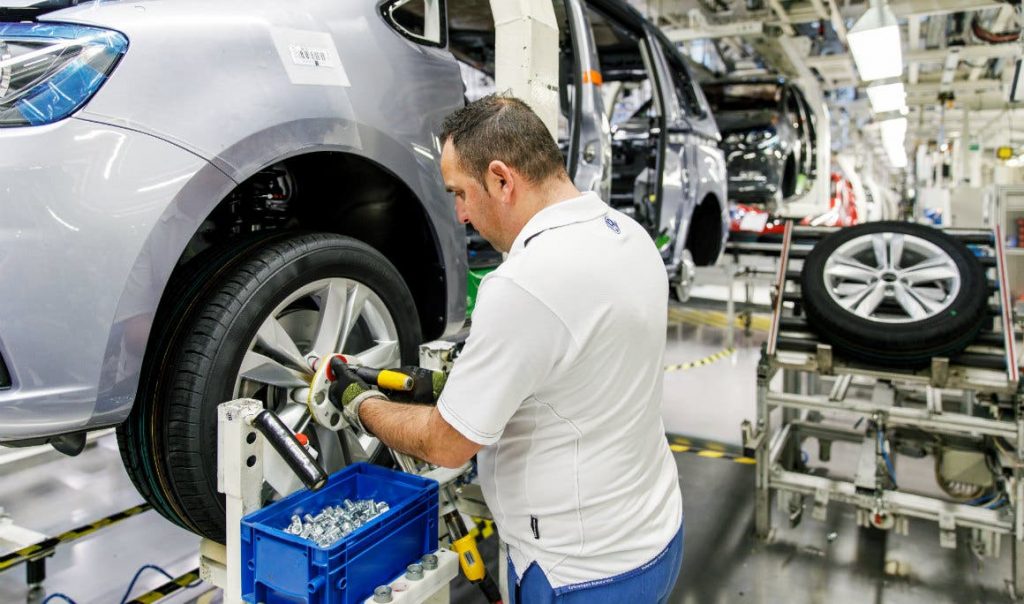 a car mechanic using a 3d printed tool to help fit a wheel