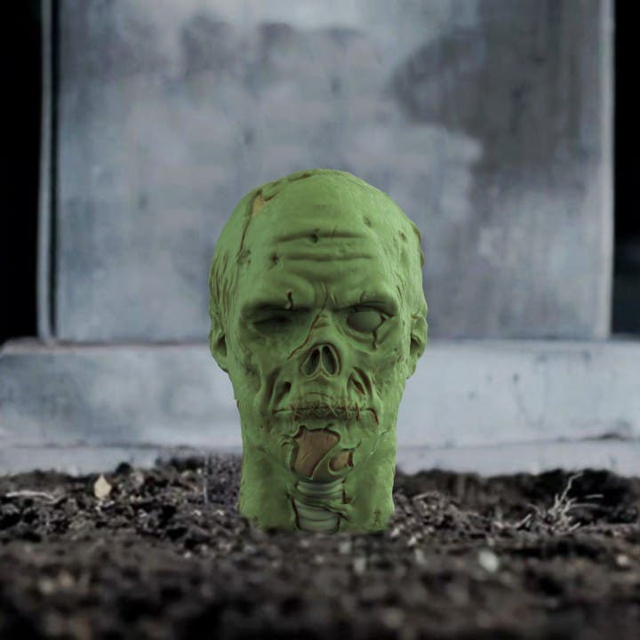 a 3d printed zombie head looking like its emerging from the ground