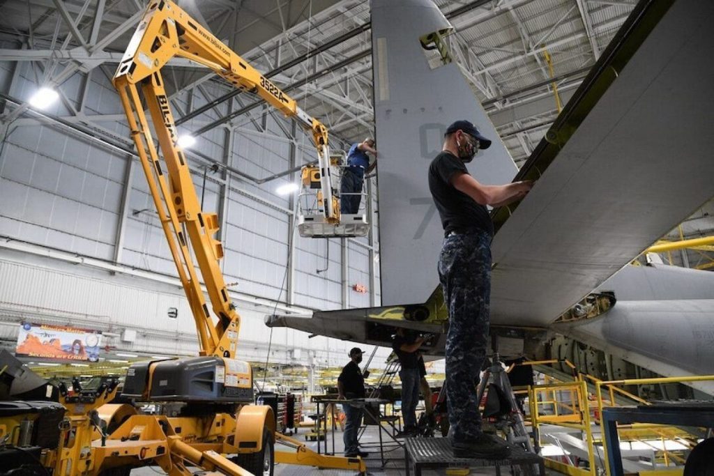 A man working on an airplane wing in a hangar