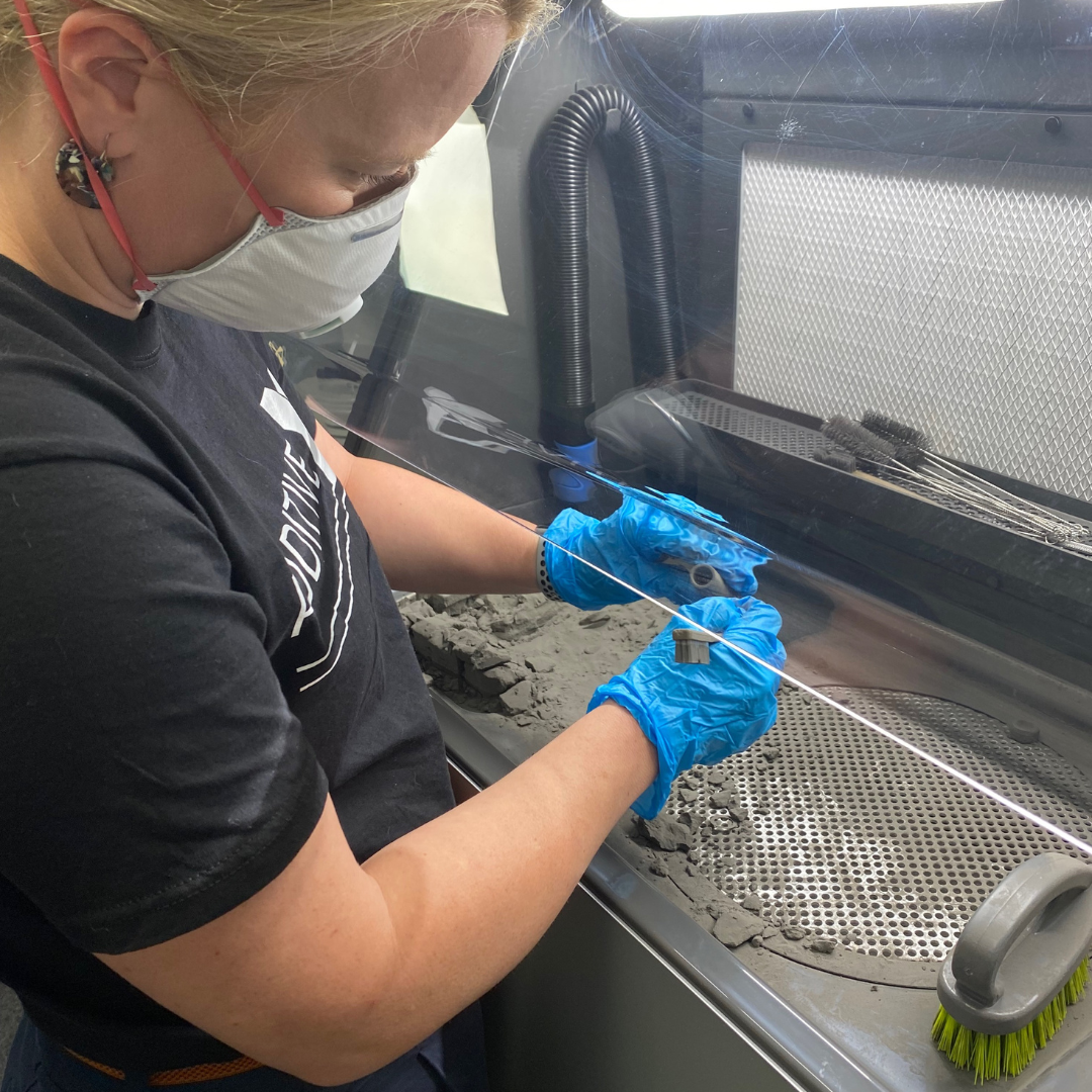Additive-X team member operating the Fuse Sift to process a part.