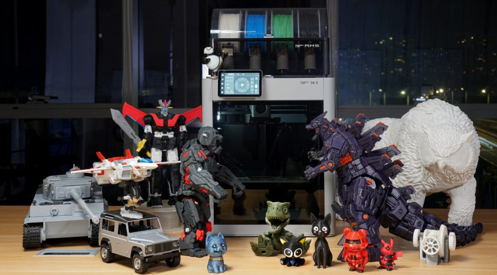 Bambu Lab X1 Carbon Combo 3D printer with an assortment of colourful, intricate prints that it has produced.