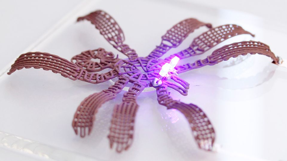 A spider-shaped 3D printed model made from metallic gel.