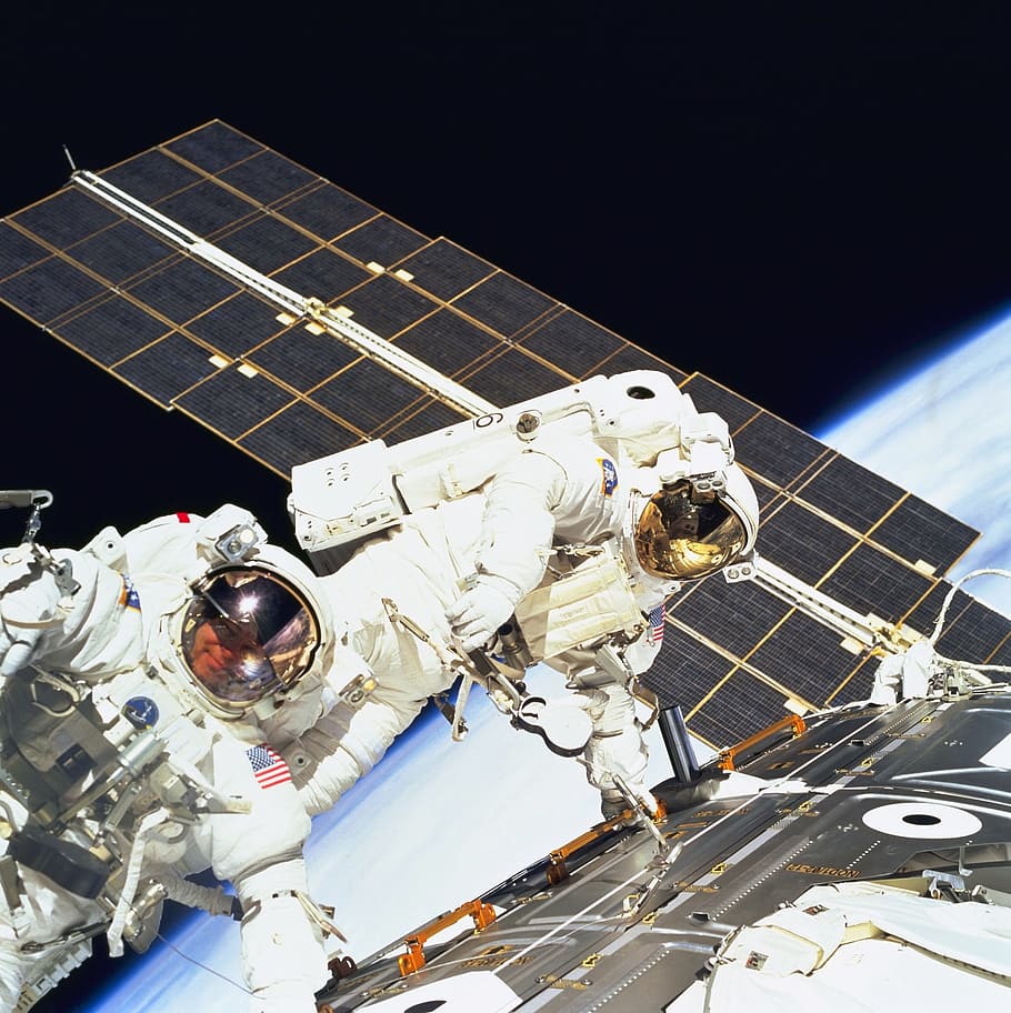 Two astronauts outside the international space station performing maintenance.