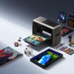 EufyMake E1 3D-texture UV printer with several full-colour raised-texture print samples displayed around it