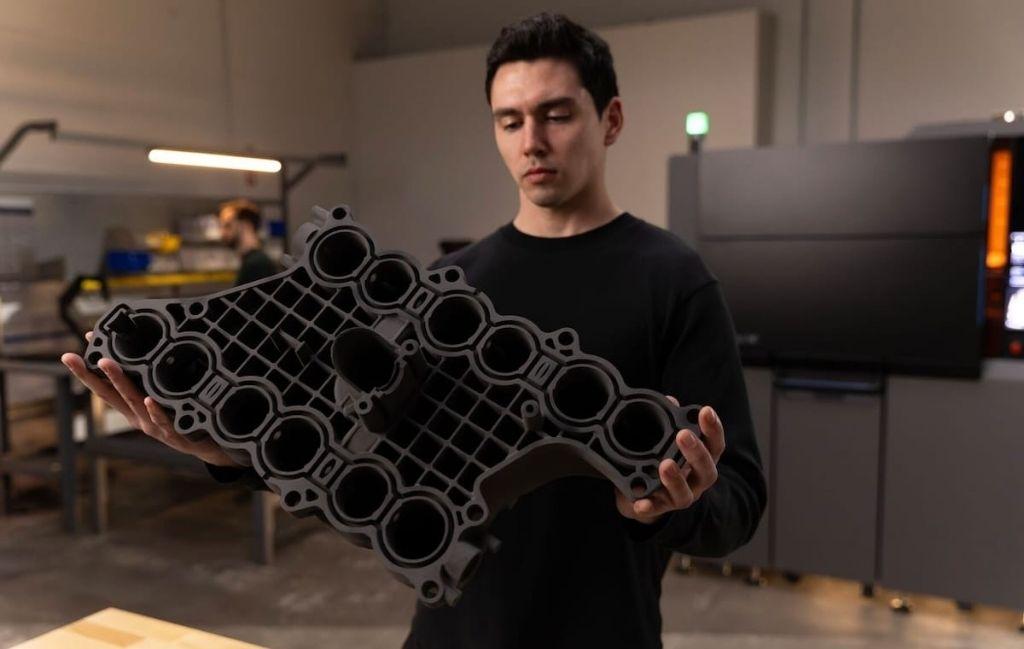 Large nylon SLS part printed on the Formlabs Fuse X1, held to show its size and complex geometry