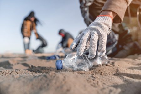 Volunteering man picking up rubbish on the beach